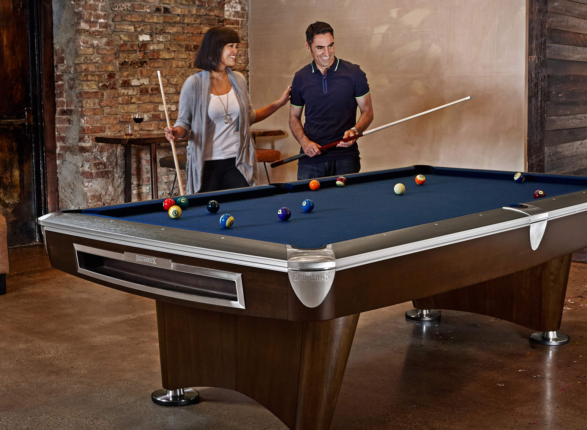 Couple playing billiards at home